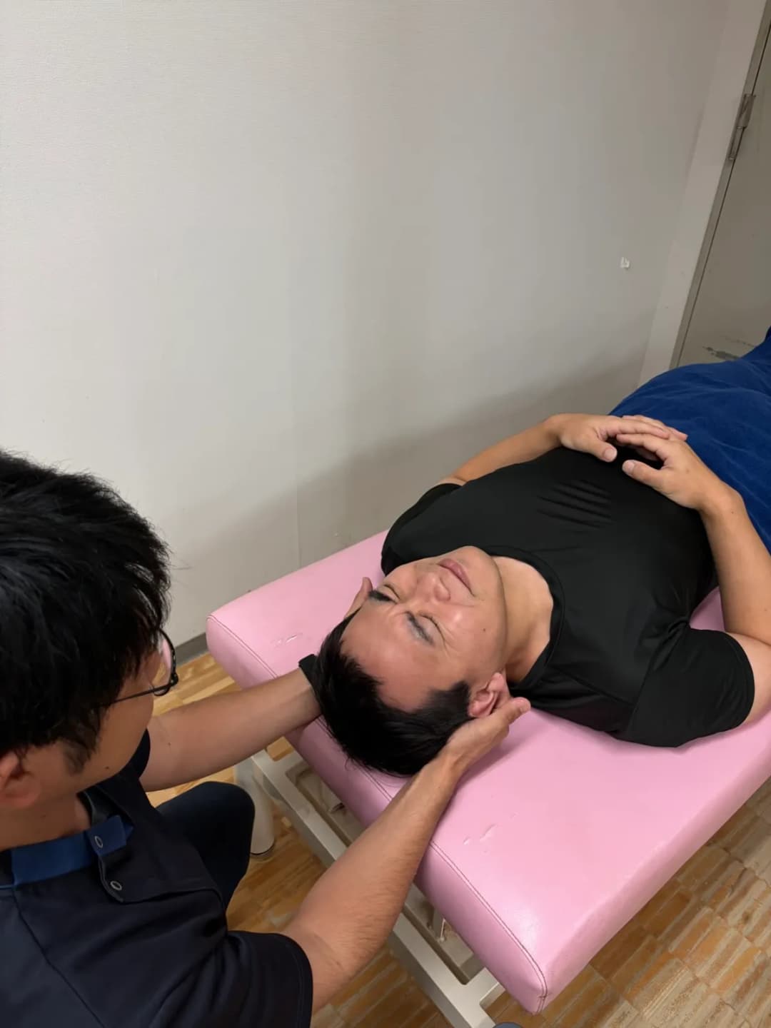 首から後頭部にかけて施術を行っている様子