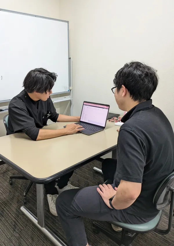 パソコンの画面を見せながら通院プランを説明するスタッフ